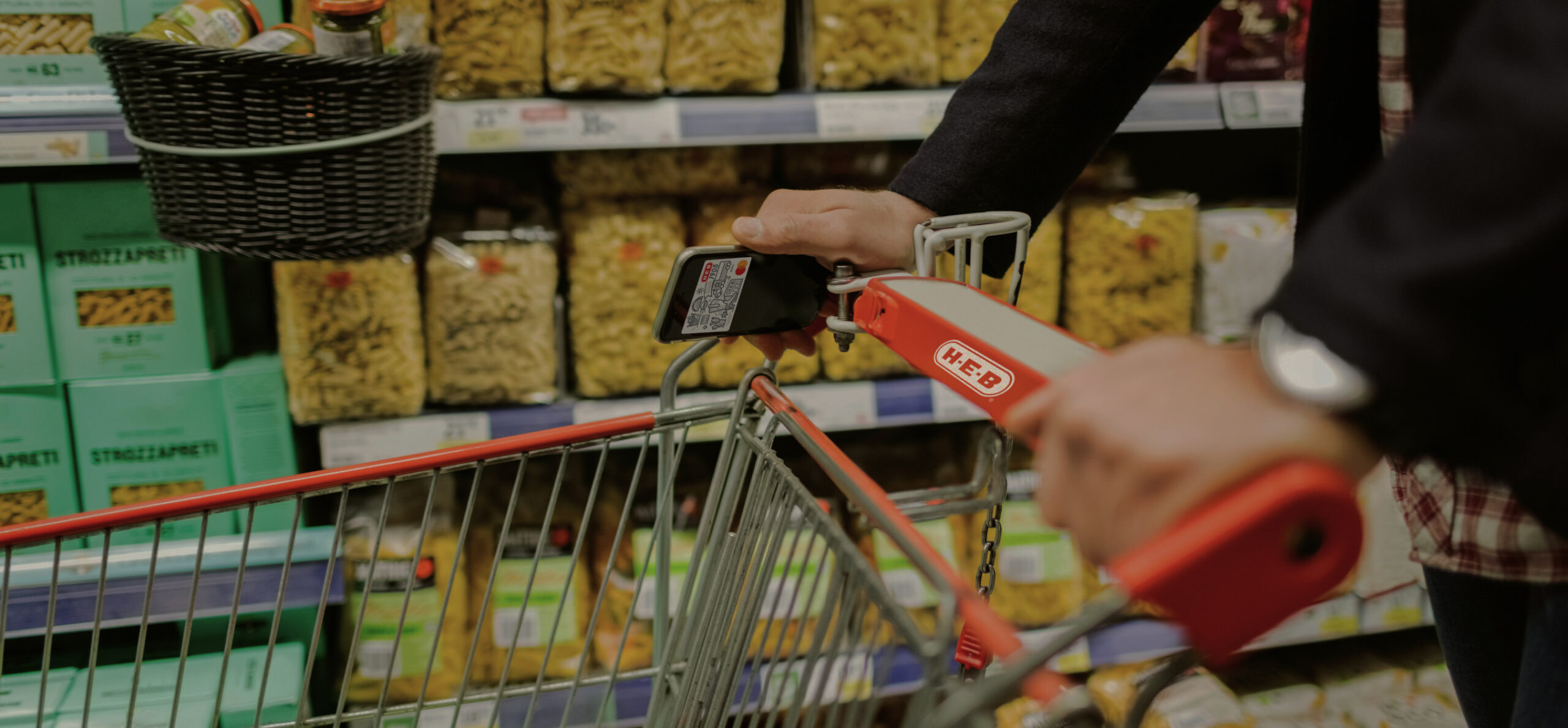 H-E-B digital debit card displayed on an iphone while someone is shopping